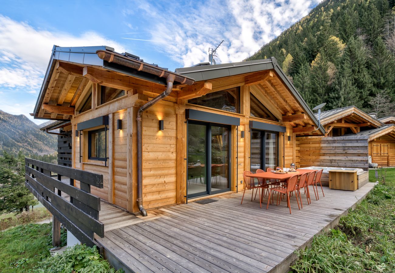 Chalet Green Forest a une terrasse en bois avec mobilier de salle à manger et jacuzzi