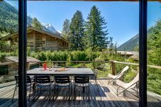 Chalet Black Stone a des portes vitrées donnant sur un balcon ensoleillé