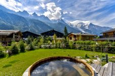 Chalet les Trois Soeurs a un grand jacuzzi en bois  