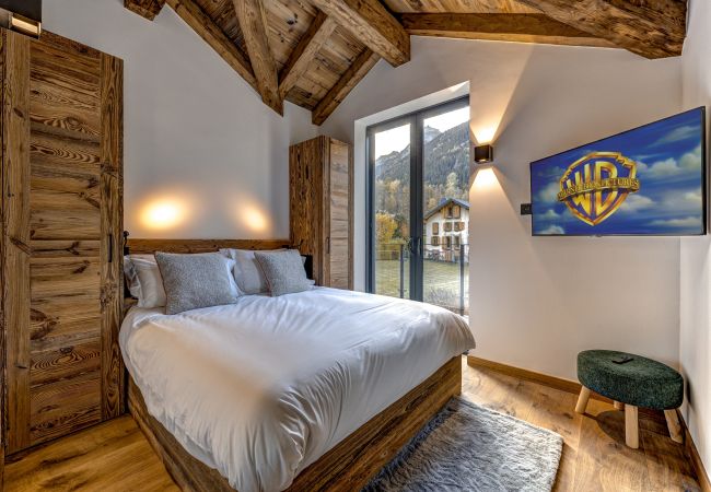 Bedroom 5 with glass doors onto balcony Bedroom 5 of Chalet les Côtés du Lavancher has glass doors onto a balcony.