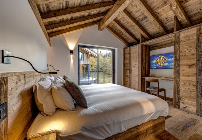 Bedroom 4 with glass doors onto balcony  At Chalet les Côtés du Lavancher, Bedroom 4  has glass doors onto a balcony.