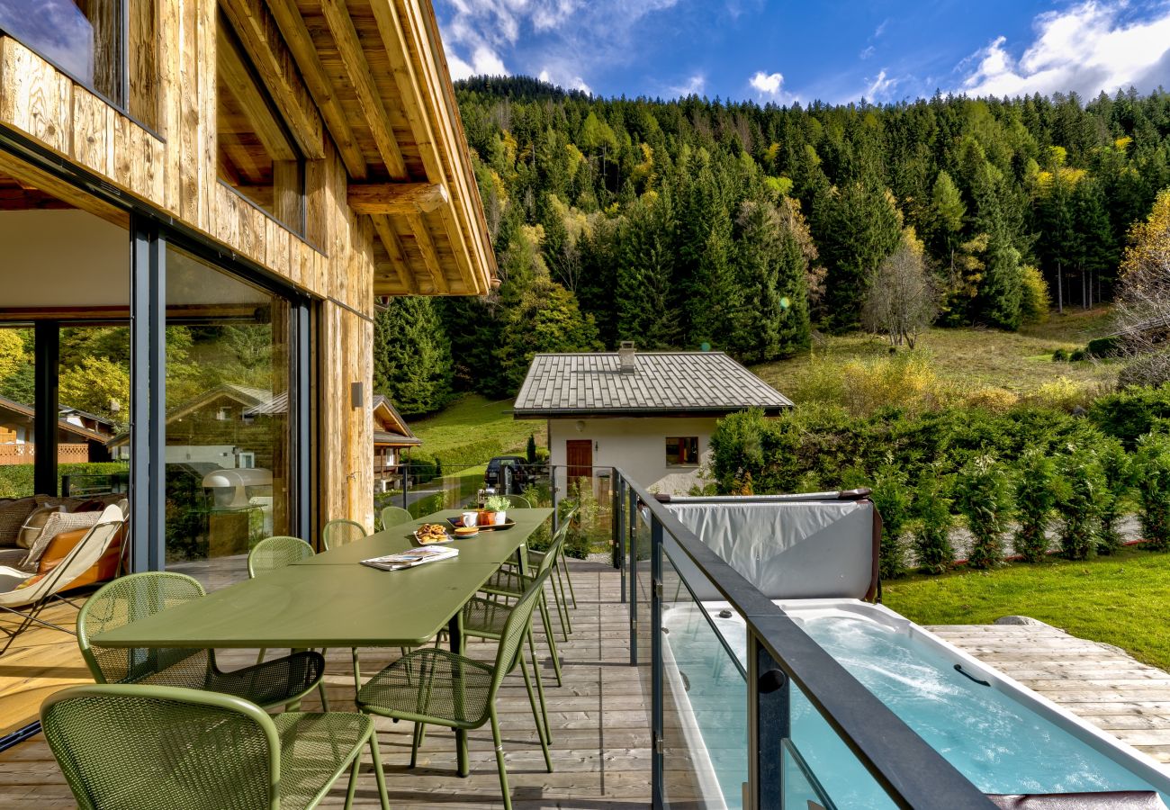 Balcony with dining furniture overlooking large hot tub Chalet les Côtés du Lavancher has a balcony with dining furniture overlooking a large hot tub.
